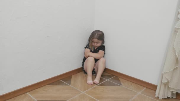 Θλιβερό Αναστατωμένο Κοριτσάκι Κάθεται Στη Γωνία Του Δωματίου Κοριτσάκι Αγκαλιάζεται — Αρχείο Βίντεο