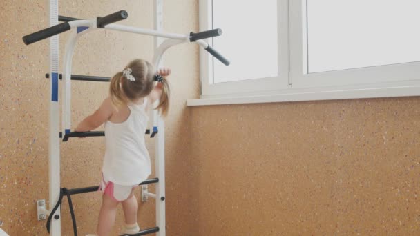 Cute Little Girl Kucykami Sprawia Niektóre Ćwiczenia Fizyczne Barze Sportowym — Wideo stockowe