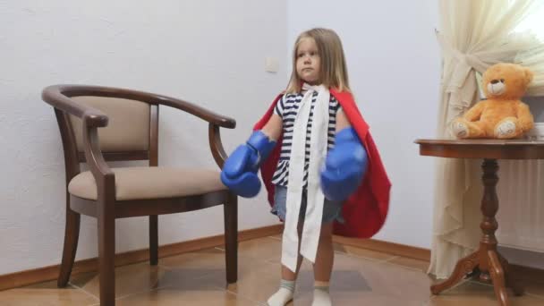 Aranyos Kislány Bokszolókesztyűvel Játszik Vicces Kislány Piros Köpenyben Bolondozik Otthon — Stock videók