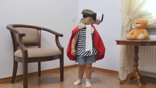 Linda Niña Capa Roja Gafas Virtuales Está Pie Casa Mira — Vídeo de stock