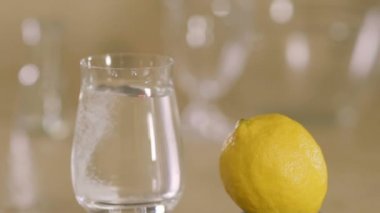 Fışkırtıcı tablet suyla dolu bir bardağa düşer. Sağlıklı yaşam tarzı ve tıbbi tedavi. Yakın plan. Yavaş çekim.