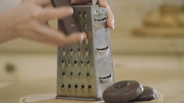 Frau Reibt Schokolade Mit Stahlreibe Auf Schneidebrett Der Küche Nahaufnahme — Stockvideo