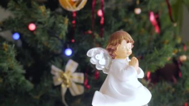 Kirpi kendi elleriyle yaptı. Oyuncak kameranın önünde dönüyor. Arka planda Noel topları olan Noel ağacı.