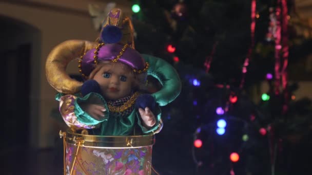 漂亮的笑话玩具 穿着漂亮亮丽衣服的娃娃从一边走到另一边 背景上有圣诞球的圣诞树 后续行动 — 图库视频影像