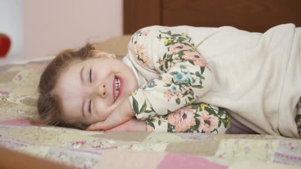 可爱的女孩睡在家里的床上 这个女孩累了 午饭后放松了 她在梦中笑 可爱的小女孩在家里的画像 — 图库视频影像