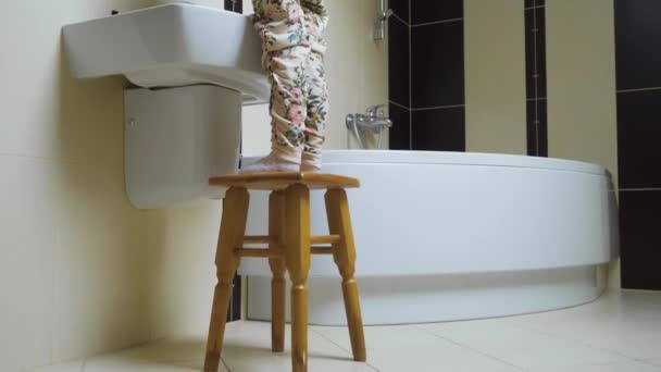 小女孩站在镜子前 坐在浴室的椅子上 为自己化妆 可爱的孩子变得像她的成年母亲 那女孩正在用粉刷粉刷腮帮子 — 图库视频影像