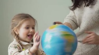 Küçük kız ve annesi evde birlikte çalışıyorlar. Aile coğrafyayı inceler ve dünyayı çarpıtır. Sevimli küçük kızı olan genç bir anne, ülkeleri bir oyun formunda okuyor..