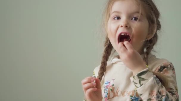 Een Klein Meisje Eet Snoepjes Kijkt Naar Camera Schattig Schattig — Stockvideo