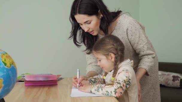 Mamma Hjälper Sin Lilla Dotter Att Göra Läxor Hemma Ung — Stockvideo