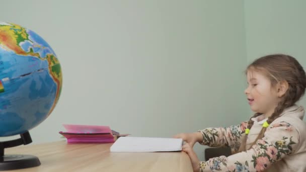 Mała Dziewczynka Siedzi Przy Stole Jest Nudna Bierze Notatnik Stołu — Wideo stockowe