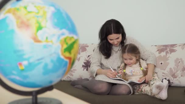 Mutter Hilft Ihrer Kleinen Tochter Bei Den Hausaufgaben Hause Junge — Stockvideo
