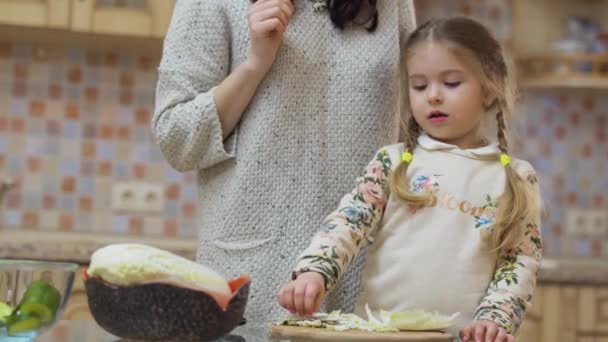 Fiatal Anya Tanítja Kislányát Főzni Konyhában Kislány Megkóstolja Káposztát Élvezi — Stock videók