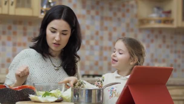 Ibu Muda Duduk Meja Dapur Dan Memasak Salad Segar Putri — Stok Video