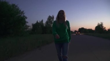 Genç bir kadın el sallayarak onu takip etmeni istiyor. Yeşil kazaklı sarışın kız yol boyunca koşuyor. Akşam vakti dışarıda vakit geçirmek.