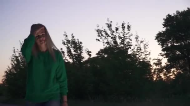 Блондинка Зеленом Свитере Идет Дороге Поправляет Волосы Леди Смотрит Камеру — стоковое видео