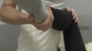 Yakın çekim erkek elleri masaj masasına yatan genç kadının dizine masaj yapıyor. Masaj terapistindeki kız. Sağlık, tedavi, rekreasyon, tıp kavramı