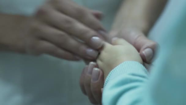 Mãos doutor feminino jovem que massageia mãos do pequeno paciente, acalmando a criança. Conceito de cuidados de saúde, tratamento, recreação, medicina. Pediatra examinando a criança — Vídeo de Stock