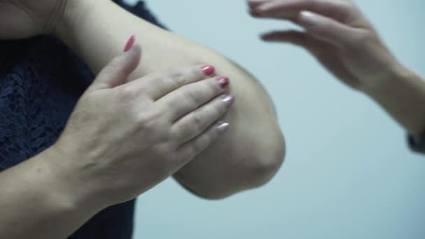 Primer plano de la doctora pofessional caucásica revisando el brazo de una anciana en el consultorio. La señora madura fue al hospital con trauma. Concepto de salud, tratamiento, medicina, recreación — Vídeo de stock