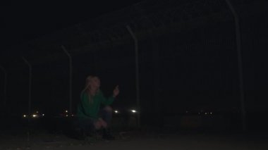 Yeşil kazaklı sarışın kız uçağın ön koltuğunda sigara içiyor ve kalkıyor. Kamera uçağı takip eder ve sola gider.