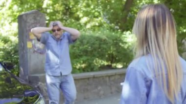 Kızgın şoför arabasından inip, arabasının altında kalan sağır ve dilsiz genç kıza bağırmaya başladı. Mutsuz kadın, arabayı duymadığını ve uygunsuz davranışından dolayı özür dilediğini kendi elleriyle açıklamaya çalışıyor..