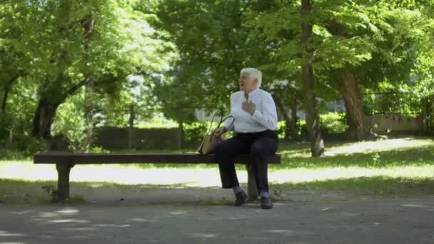 Старуха Сердечным Приступом Сидит Скамейке Парке Просит Помощи Прохожих Молодая — стоковое видео