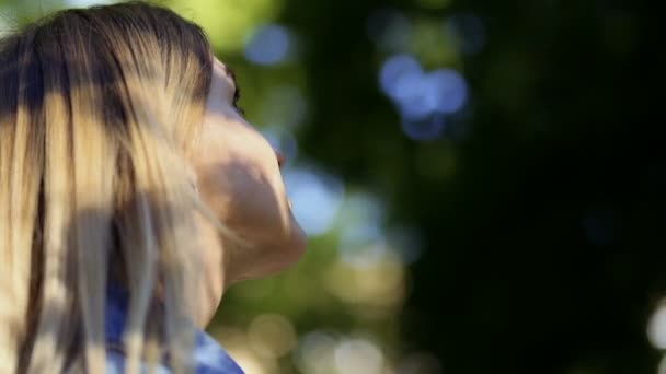 公園の木を見ている若い女性 美しい女性は夏の自然を楽しむ — ストック動画