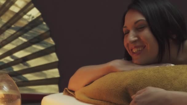 Masaj Salonundaki Güzel Kız Masaj Için Yatağa Uzanıyor Mumlar Yatmadan — Stok video
