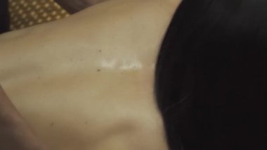 Masözün elleri kızın arkasını ve yanlarını okşuyor. Yakın plan..