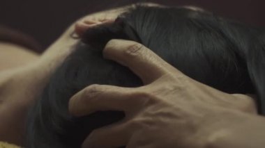 Masaj salonunda hoş bir kız. Güzellik uzmanı kadın yüzlerine masaj yapıyor. Masaj suratlı kız yakın plan..