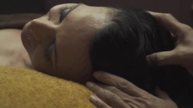 Güzel kız yüz masajı yaptırıyor. Kadın kozmetik merkezindeki yüz masajından zevk alıyor. Vücut bakımı, cilt bakımı, sağlık, güzellik tedavisi. Yakın plan..