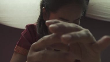 Kırmızı sabahlıklı Tayland masözü bir kıza dirsek masajı yapıyor. Yakın plan..