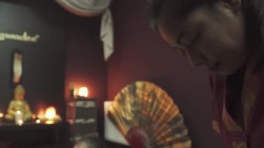 Tayland masaj salonundaki bir adam için sırt masajı. Taylandlı masöz sırt masajı yapar. Masanın üzerinde yanan mumlar var..