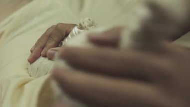 Bitkisel torbalarla Tayland masajı. Yakışıklı adam masaj yatağında iyi vakit geçiriyor. Yakın plan..