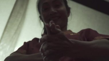 Güzel Taylandlı masöz masaj salonunda ellerini yağla ovuyor. Bir kadın tatlı tatlı gülümsüyor. Yakın plan..