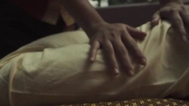 Taylandlı masöz, bir erkeğin lig maçlarına masaj yapar. Yakışıklı çocuk masaj yatağında yatıyor. Yakın plan..