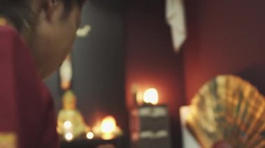 Taylandlı masaj terapisti mutlu adama masaj yapar. Çocuk masaj masasında yatıyor. Masanın üzerinde arka planda mumlar yanıyor..