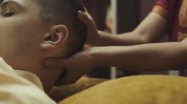 Adamın boynuna ve kafasına masaj yapan profesyonel Thai masaj terapistinin ellerini kapat. Yakın plan..