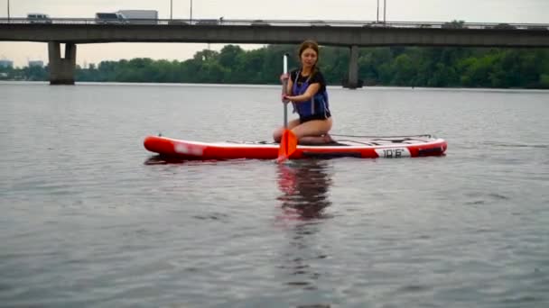 Young Beautiful Brunette Sits Kayak Row River Automobile Bridge Background — ストック動画