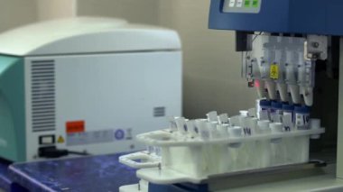 Laboratuvarda analizlerle otomatik çalışma. Laboratuvardaki elektronik ekipman test tüpleriyle çalışıyor. Araştırma yapan makineler. Uyuşturucu imalatı. Bilim, meslek, sağlık konsepti