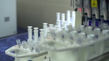 Modern laboratuarda, masada test tüpleri ve şırıngalar olan elektronik ekipmanlar. Uyuşturucu imalatı. Araştırma yapan makineler. Bilim, meslek, sağlık