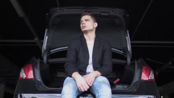 Χαλαρός Νεαρός Κάθεται Στο Ανοιχτό Αυτοκίνητο Και Μασάει Τσίχλα Άντρας — Αρχείο Βίντεο