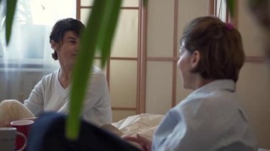 İki olgun kadın evde birlikte vakit geçiriyorlar. İki zarif olgun kız evde rahatlatıcı, konuşma ve haber paylaşımı. Dostluk, sağlıklı yaşam, mutlu yaşam kavramı. Yavaş çekim.