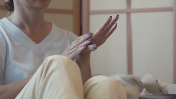 Onherkenbaar vrouw aanbrengen van de crème op haar handen thuis close-up. Aanbrengen van crème, masserende handen. Concept van lichaamsverzorging, schoonheid, vrouwelijkheid — Stockvideo