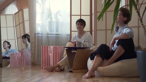 Two cute adult women spending time at home together. Two elegant mature girlfriends relaxing at home, talking and sharing news. Concept of friendship, wellness, happy life. Slow motion. — Stock Video