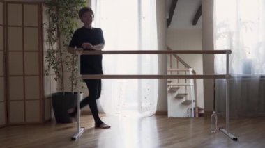 Esnek kadın evde pratik yapıyor. Siyah giysiler içinde zarif ince kadın kapalı egzersizleri yapıyor. Mutlu yaşam, formda tutmak.
