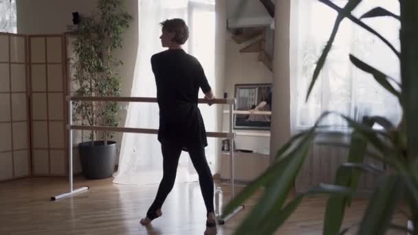 Flexibel mogen kvinna dansar hemma framför spegeln. Elegant smal kvinna i svarta kläder gör övningar inomhus. Lyckligt liv, hålla i form — Stockvideo