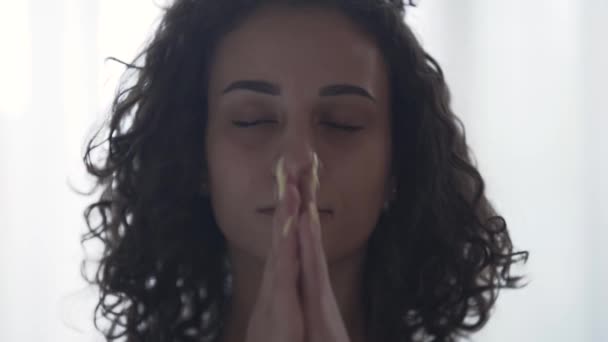 Retrato de perto de uma jovem mulher relaxante encaracolada fechando os olhos e respirando fundo. A menina fazendo ioga em casa ou no estúdio. Desenvolvimento espiritual — Vídeo de Stock