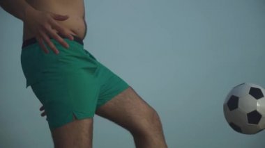 Yakışıklı adam topu ayağıyla dolduruyor. Genç adam ve top.