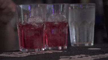 Meyve suyu bardakların üzerine dökülüyor. Barmen kokteyl hazırlıyor. İçecek..