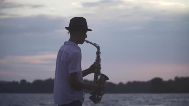 Schöner Junger Kerl Spielt Saxofon Ufer Des Flusses Typ Mit — Stockvideo